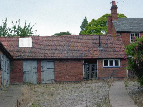 Buildings at the top of the courtyard. The entrance to the farmhouse is the path to the right. July 2007